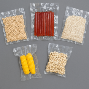 Five transparent sealed vacuum bags containing various food items including grains, corn, nuts, and meat sticks displayed on a gray background.